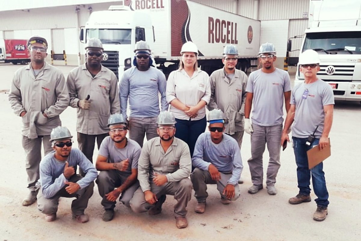Equipe de campo reunida em frente aos veículos no pátio da obra