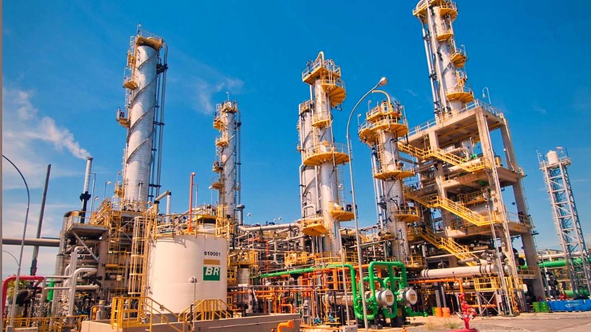 Unidade de processo da refinaria com torres, tubulação e estruturas metálicas