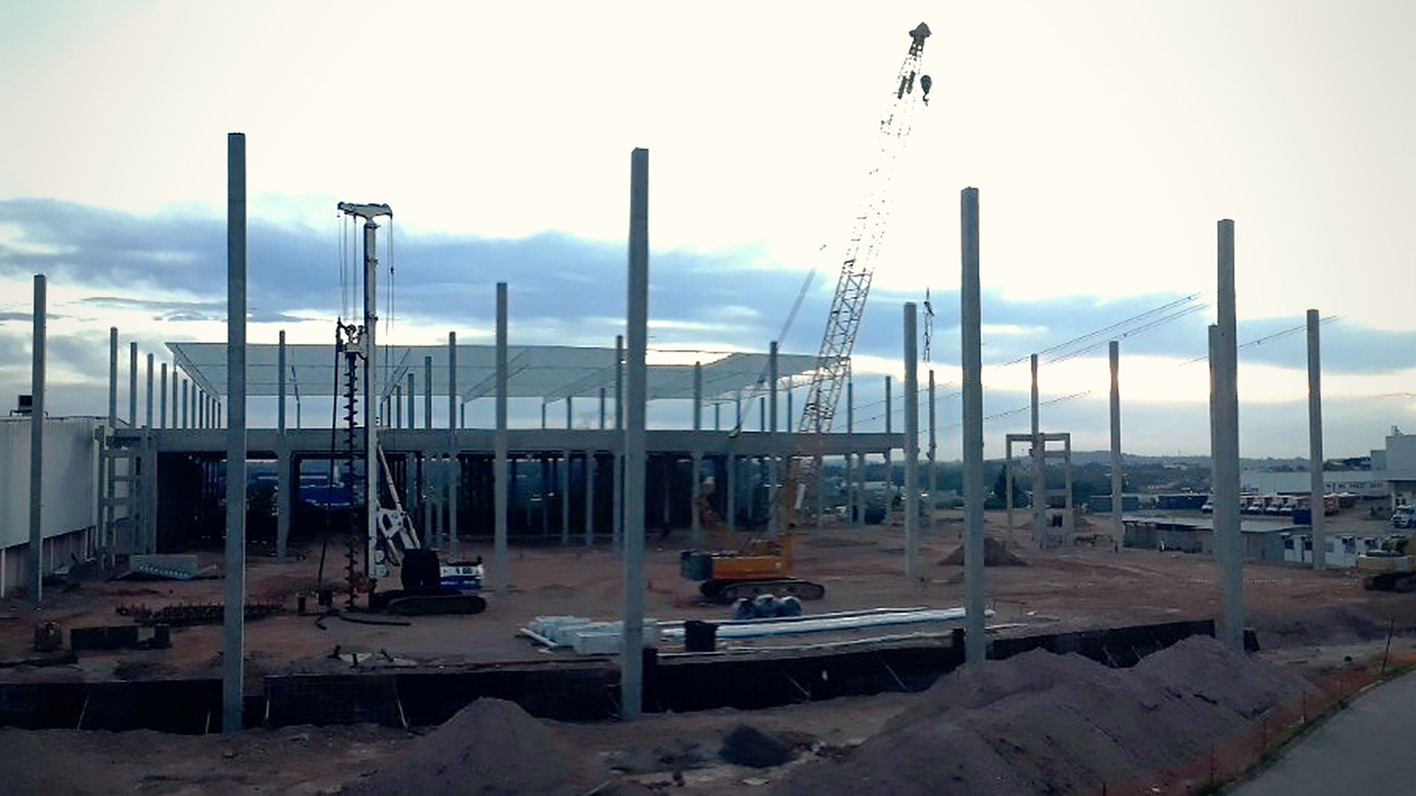 Estrutura da unidade industrial em montagem, com pilares metálicos alinhados